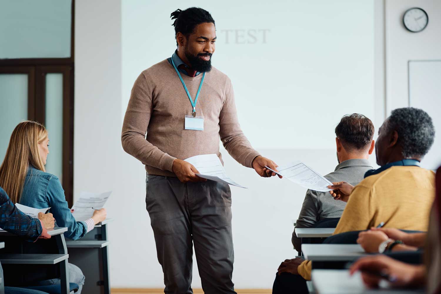 Lecturer handing out some notes in class